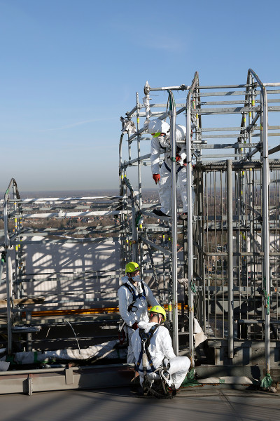Drei Gerüstbauer auf dem Dach des Gasometers