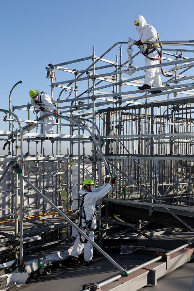 Drei Gerüstbauer bei der Demontage des Fassadengerüsts