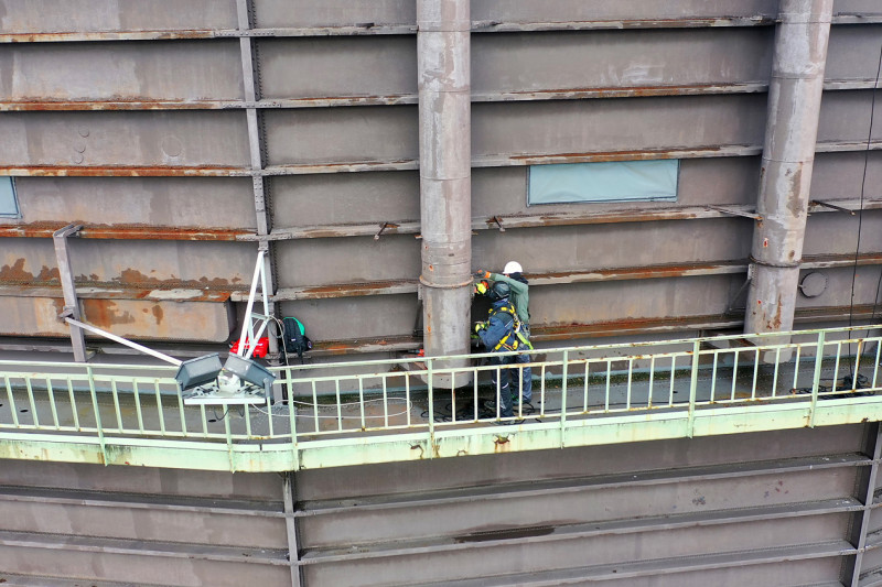 Zwei Industriekletterer demontieren einen der Ausbläser des Gasometers.