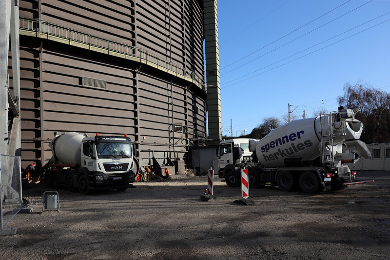 Zwei Betonmischer parken vor dem Gasometer.