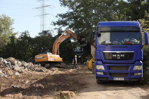Ein Bagger belädt einen LKW mit Bausschutt
