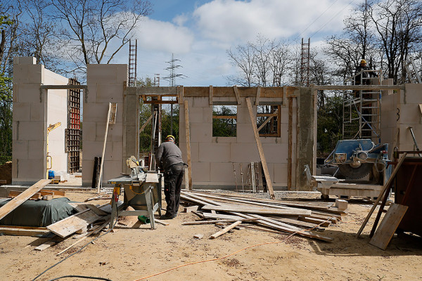 Arbeiter mit Kreissäge vor dem Rohbau der neuenGasometer-Lagerhalle