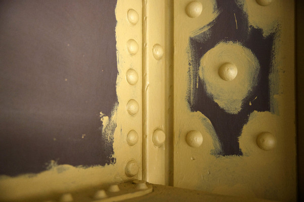 Detailaufnahme der Außenhülle desGAsometers mit bräunlicher Grundierung und gelb angestrichenen Nieten udn Schweißnäten