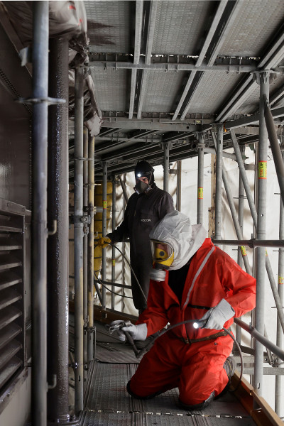 Zwei Arbeiter bei der Aufbringung der finalen Deckschicht an der Gasometer Außenhüllee