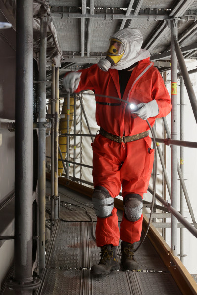 Arbeiter in Vollmontur bei der Aufbringung der finalen Deckschicht an der Gasometer Außenhüllee