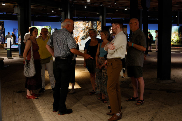 Ein Gästeführer im Dialog mit seiner Besuchergruppe in der unteren Ausstellungsebene des Gasometers.