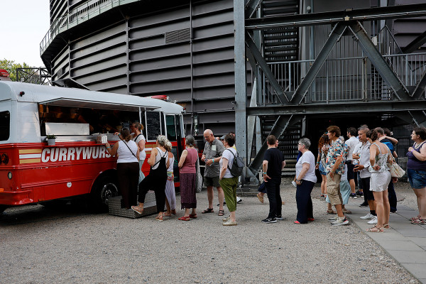 Besucher haben sich in eine Schlange eingereiht, um bei einem roten Truck-Food die obligatorische Ruhrgebiets-Currywurst zu kaufen