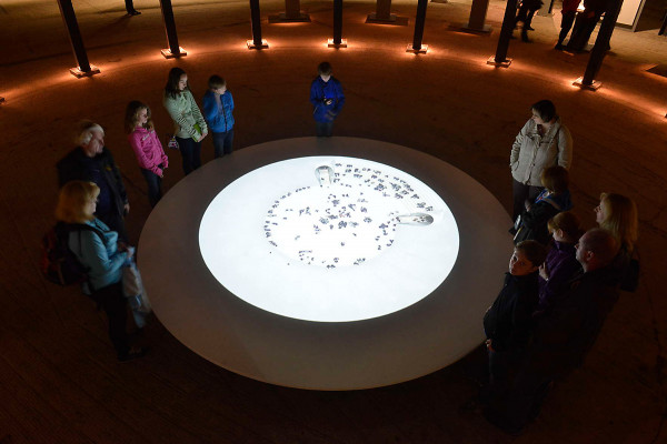 Besucher stehen um eine runde Projektionsfläche