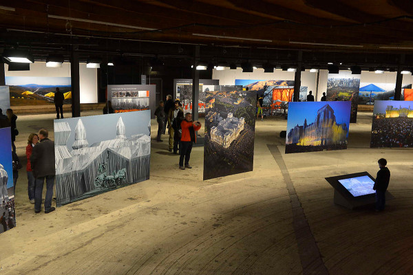 Großformatige Fotos zeigen Christos bisherige Projekte in der unteren Ausstellungsebene des Gasometerss