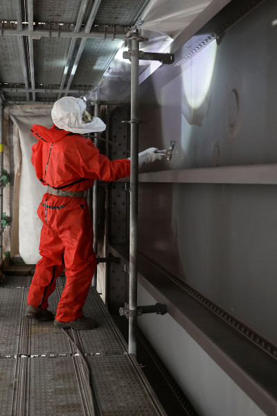Ein Arbeiter in Schutzmontur überprüft die neue Deckschicht am Gasometer